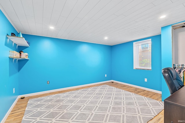 unfurnished office featuring hardwood / wood-style flooring and wooden ceiling