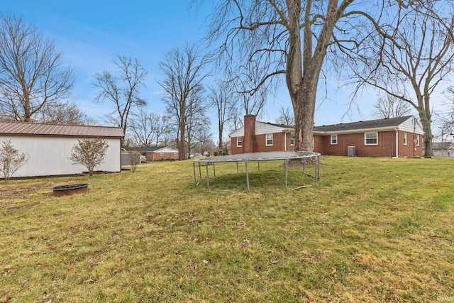 view of yard featuring central AC unit and a trampoline