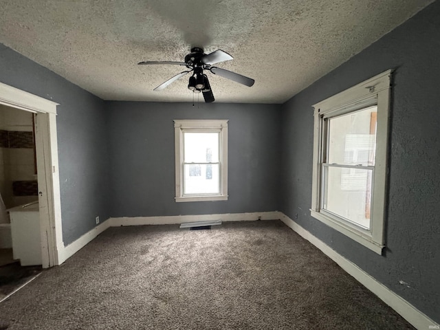 carpeted spare room with a textured ceiling and ceiling fan