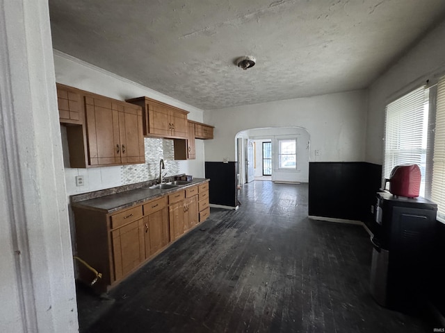 kitchen with tasteful backsplash, sink, and dark wood-type flooring