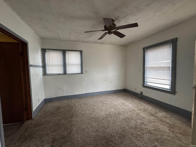 empty room with carpet, ceiling fan, and a textured ceiling