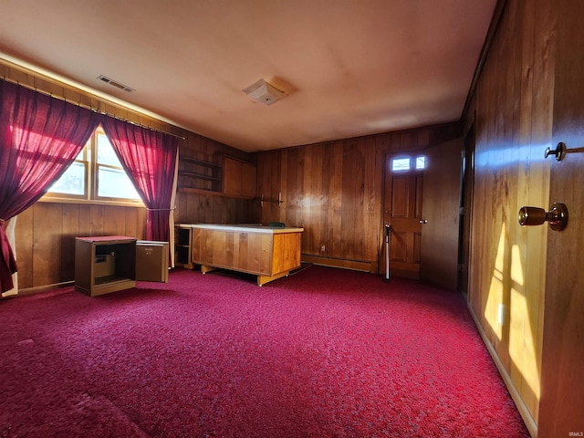 unfurnished bedroom with carpet and wood walls