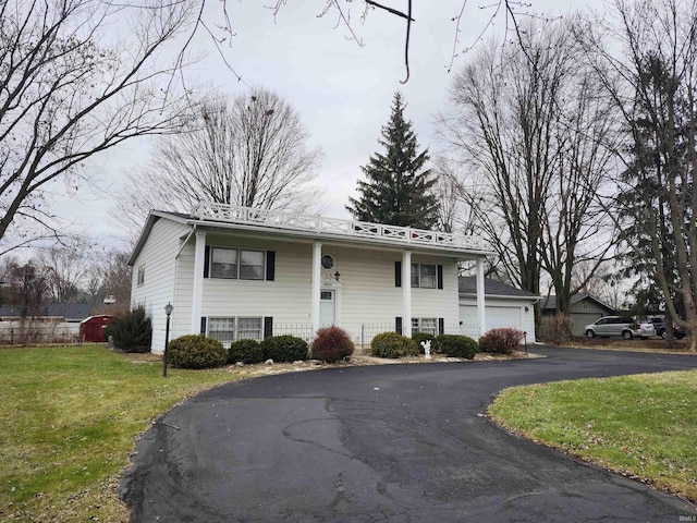 raised ranch featuring a front lawn and a garage