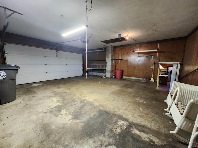 garage featuring a garage door opener and wooden walls