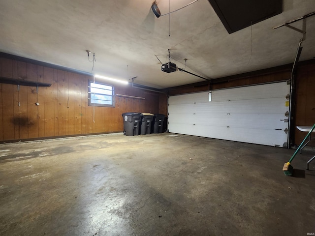 garage featuring a garage door opener and wood walls