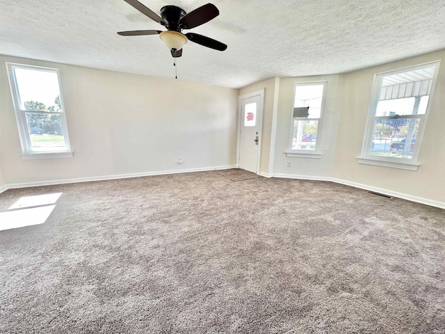 interior space featuring a textured ceiling, carpet floors, and ceiling fan