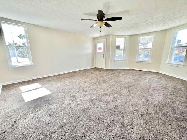 carpeted empty room featuring a textured ceiling and ceiling fan