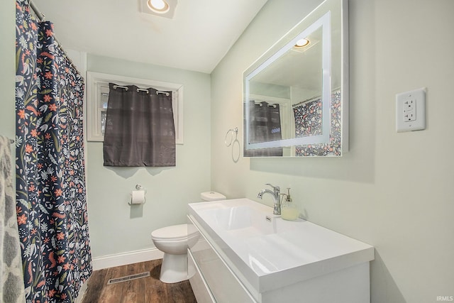 bathroom with toilet, vanity, and hardwood / wood-style flooring