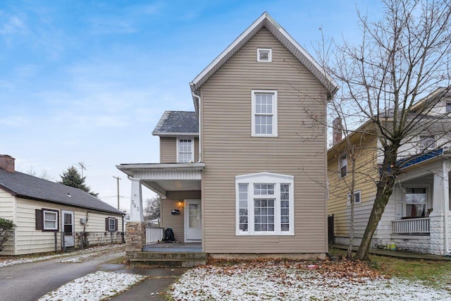 rear view of property featuring covered porch