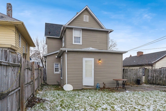 view of snow covered rear of property