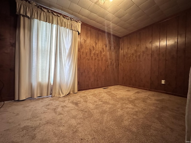 empty room with carpet and wooden walls