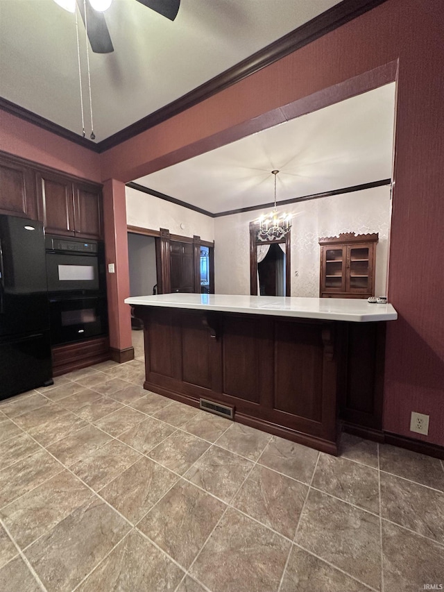 kitchen featuring kitchen peninsula, crown molding, decorative light fixtures, black appliances, and ceiling fan with notable chandelier