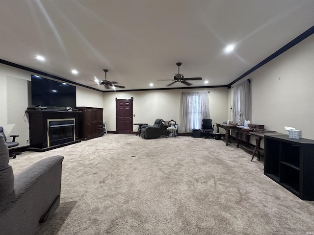 carpeted home theater room featuring ceiling fan and ornamental molding