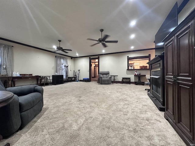 cinema with ceiling fan, crown molding, and light carpet