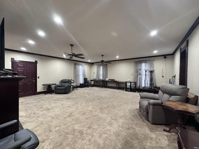 cinema with crown molding, ceiling fan, and light colored carpet