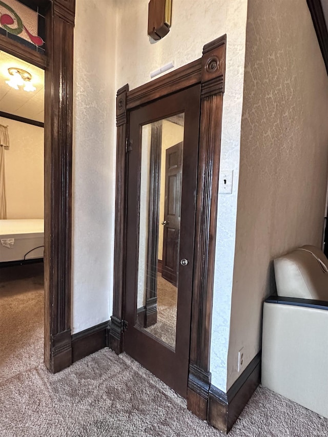 hallway featuring carpet flooring and crown molding