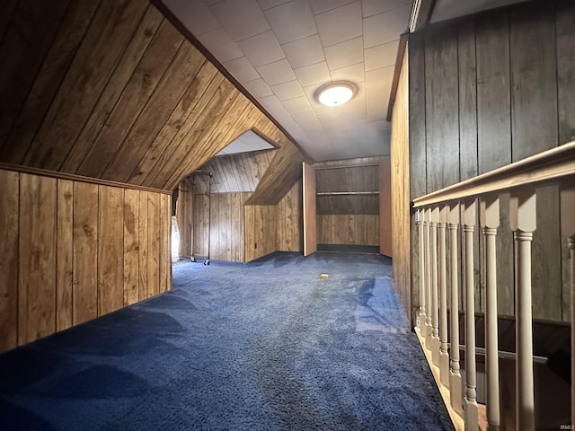 additional living space featuring wood walls, wooden ceiling, dark carpet, and vaulted ceiling