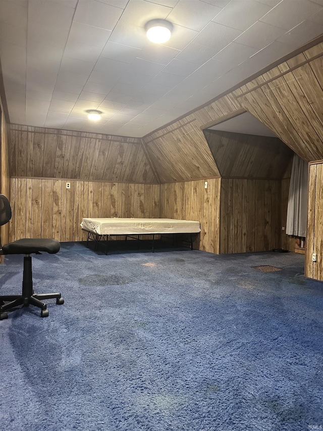 additional living space with carpet flooring, wooden walls, and lofted ceiling