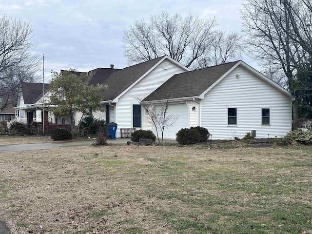 view of side of property featuring a yard and a garage