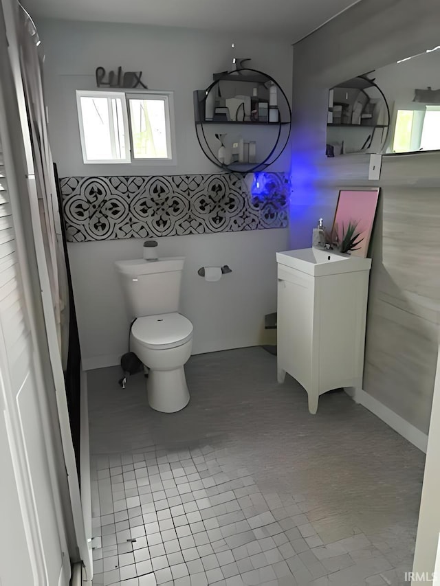 bathroom with toilet, vanity, and tile patterned floors