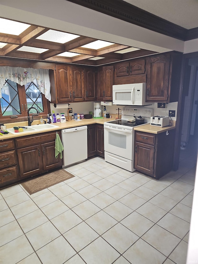 kitchen featuring light tile patterned floors, white appliances, and sink