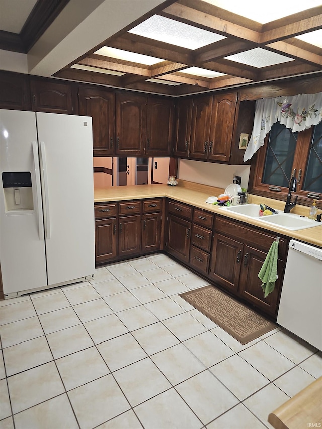 kitchen featuring dark brown cabinets, light tile patterned flooring, white appliances, and sink