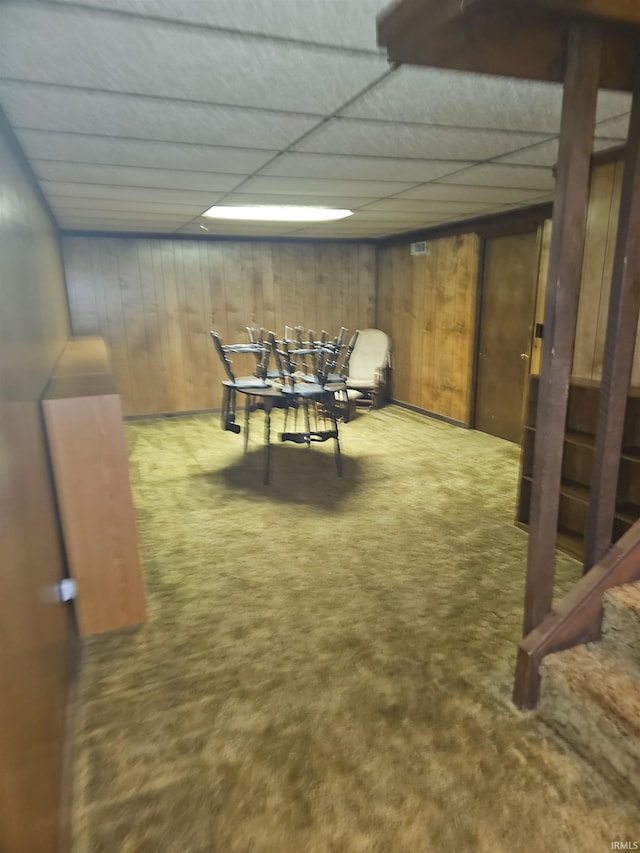 playroom featuring a paneled ceiling, wooden walls, and carpet