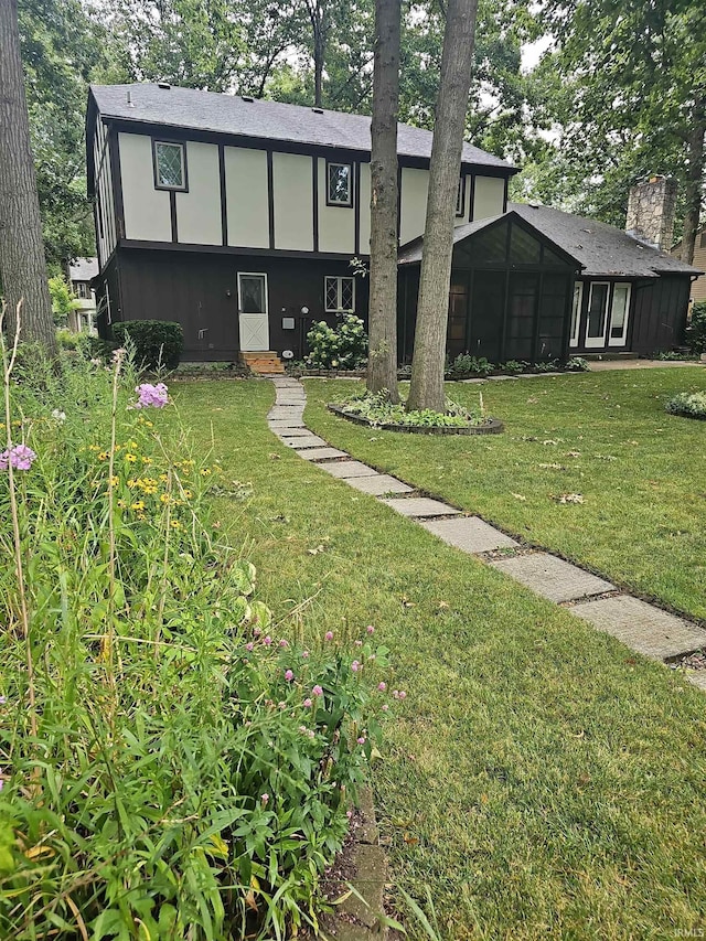 exterior space featuring a front lawn and a sunroom