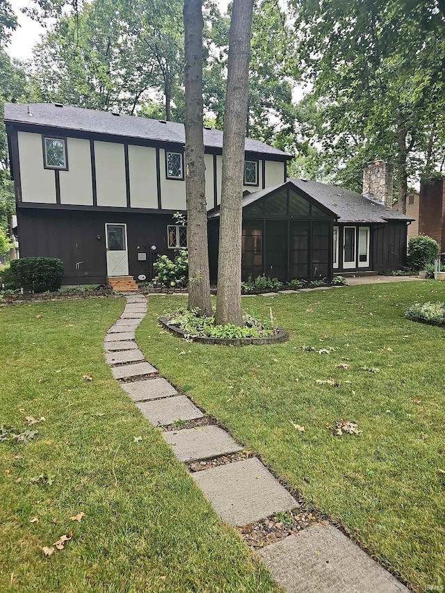 view of front of property featuring a sunroom and a front yard