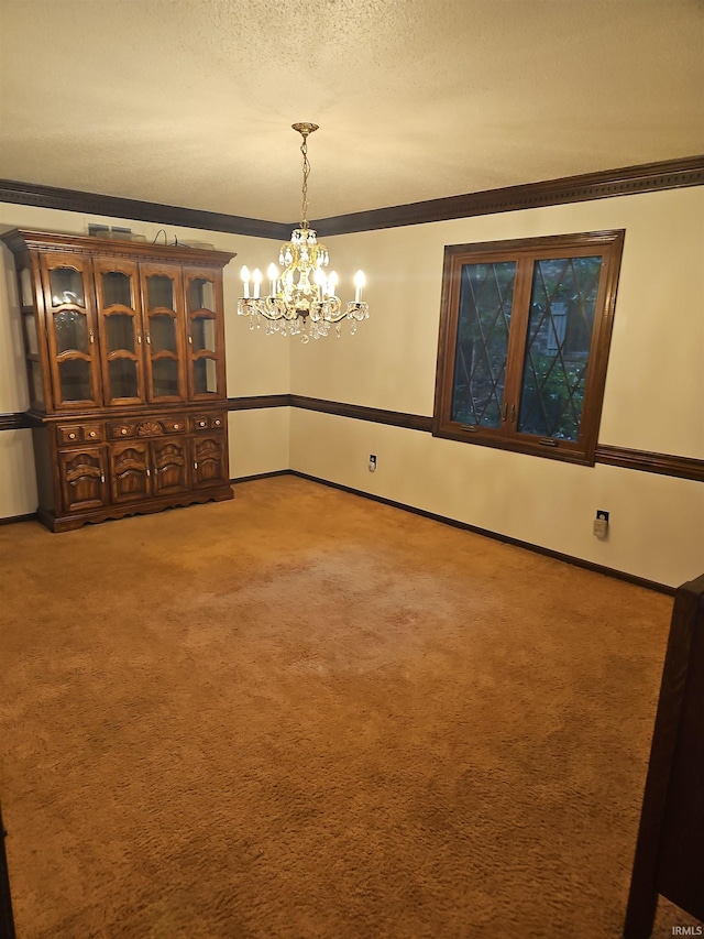 unfurnished dining area featuring a textured ceiling, carpet floors, crown molding, and an inviting chandelier