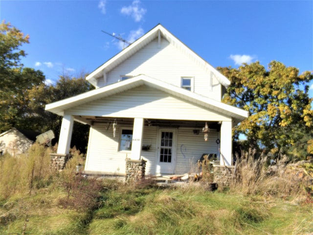 rear view of house featuring covered porch