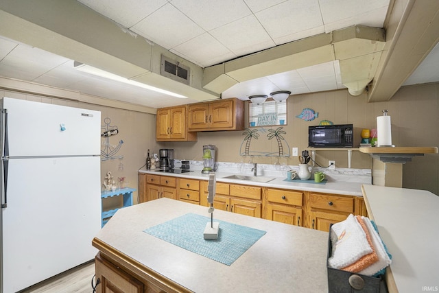 kitchen featuring sink, white fridge, and light wood-type flooring