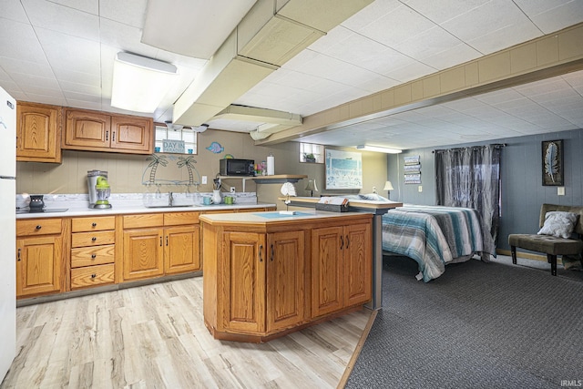 kitchen with a center island, sink, and light wood-type flooring