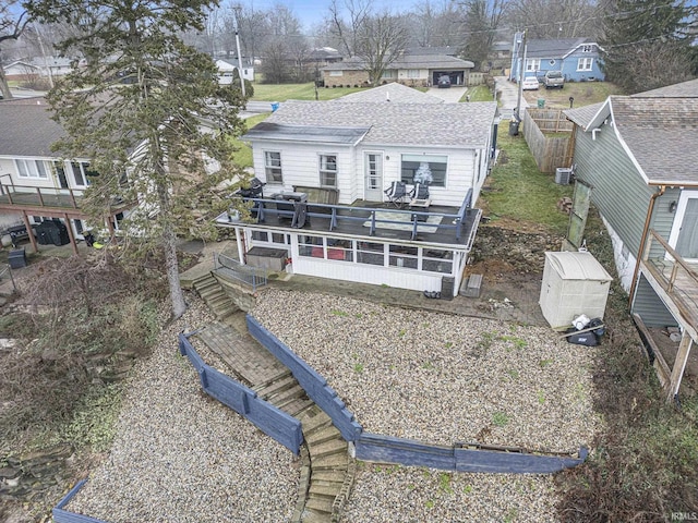 back of house featuring a wooden deck and a storage shed