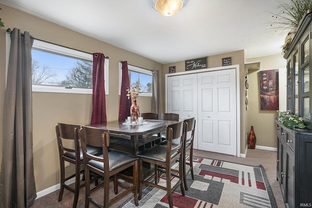 dining space featuring dark carpet