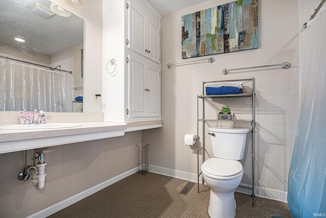 bathroom featuring toilet, curtained shower, and sink