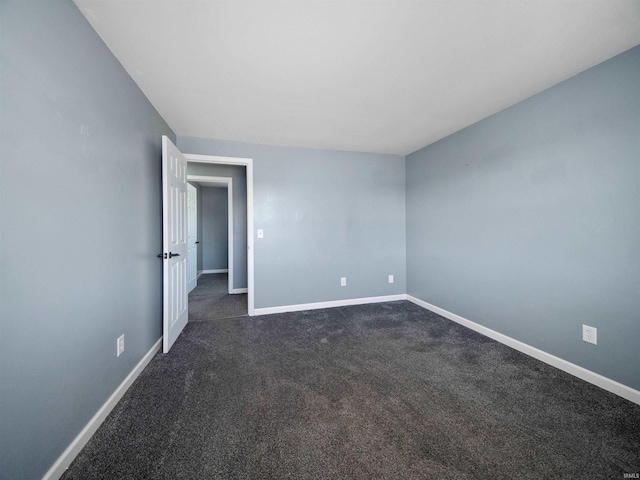 unfurnished room with dark colored carpet