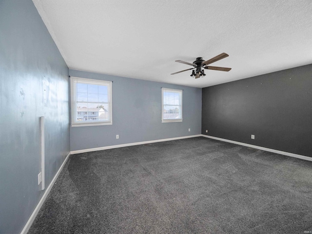 unfurnished room featuring ceiling fan, dark carpet, and a textured ceiling