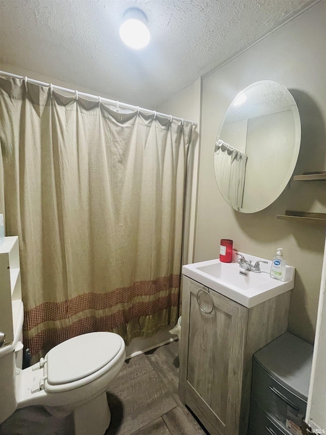 bathroom featuring hardwood / wood-style floors, vanity, a shower with shower curtain, toilet, and a textured ceiling