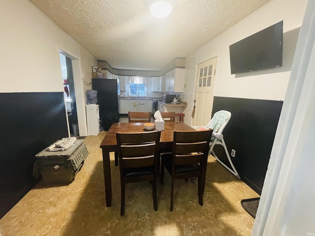 dining space featuring sink and a textured ceiling