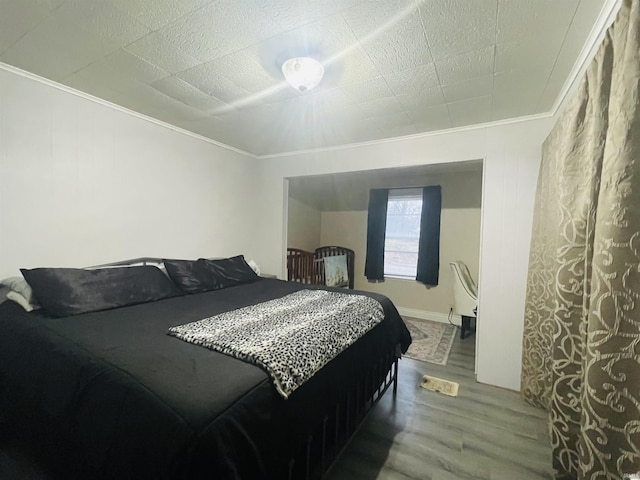 bedroom with wood-type flooring and crown molding