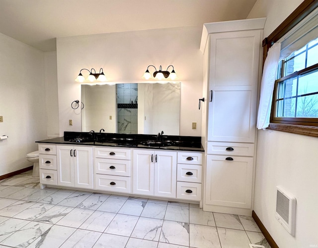 bathroom featuring a shower with door, vanity, and toilet