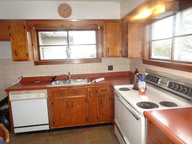 kitchen featuring backsplash, sink, a healthy amount of sunlight, and white appliances