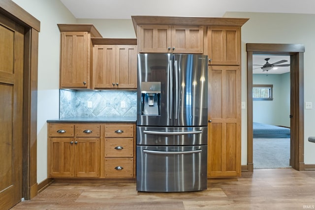 kitchen featuring decorative backsplash, stainless steel fridge, light hardwood / wood-style floors, and ceiling fan