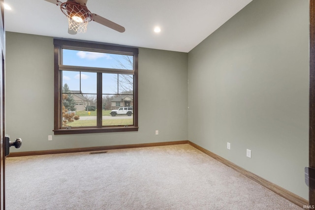 carpeted spare room featuring ceiling fan