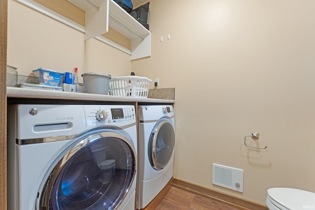 laundry room with hardwood / wood-style floors and separate washer and dryer