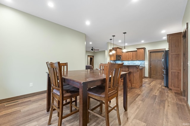 dining room with ceiling fan and light wood-type flooring