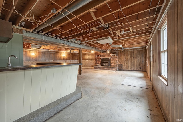 basement featuring wood walls and sink