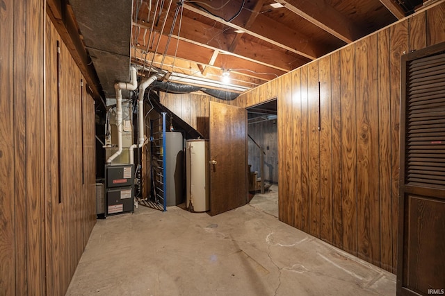 basement featuring wooden walls and heating unit