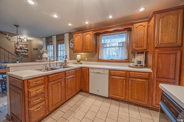 kitchen with kitchen peninsula, white dishwasher, an inviting chandelier, and hanging light fixtures